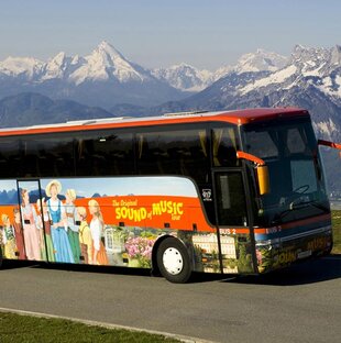The Sound of Music Tourbus on the road with mountains in background 